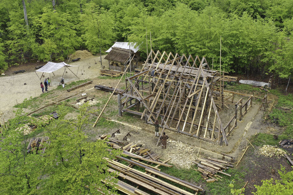 Mehrere Holzhandwerker arbeiten an der neuen Scheune, deren Dach in wenigen Wochen gedeckt werden kann. Die Mittelalter-Baustelle "Campus Galli" bei Meßkirch erhält 425.000 Euro als Corona-Nothilfe vom Land.