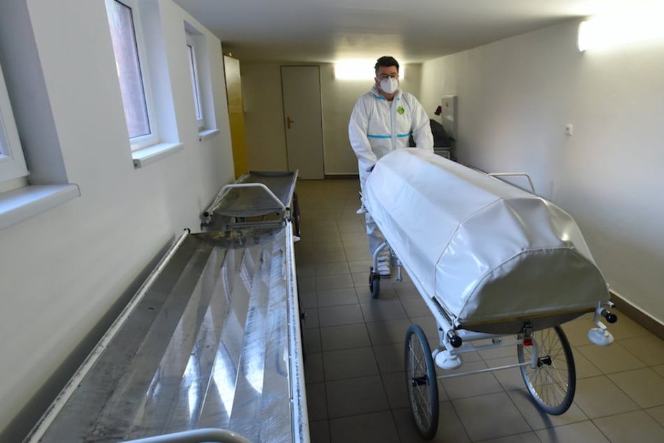 Ein medizinischer Mitarbeiter in Schutzkleidung schiebt eine Leiche in die Pathologie des Regionalkrankenhauses in Zlin.