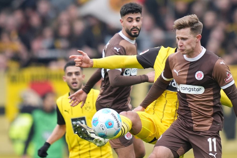 St. Pauli verwickelte den BVB immer wieder in intensive Zweikämpfe, so wie hier Johannes Eggestein (r) und Elias Saad gegen Emre Can (verdeckt).