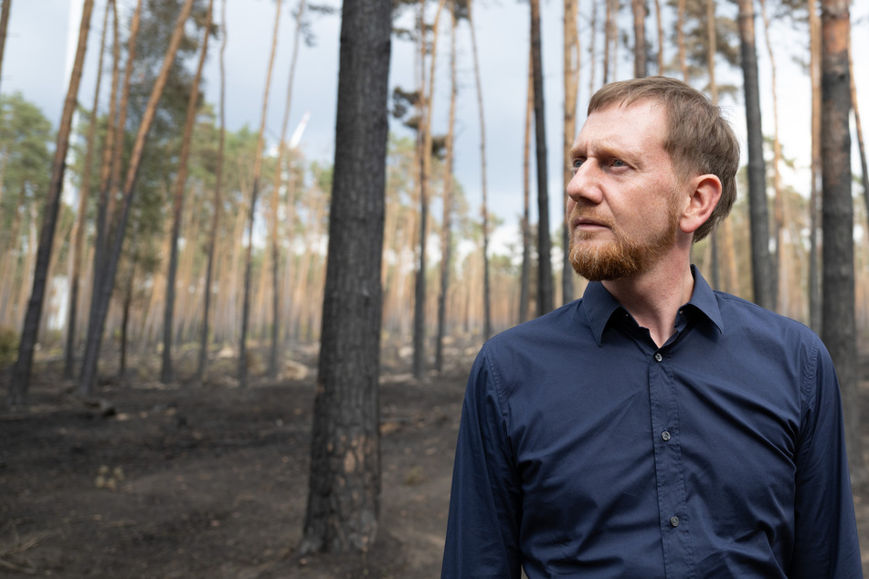 Ministerpräsident Michael Kretschmer (47, CDU) begutachtet die Schäden in einem an Brandenburg angrenzenden Waldbrandgebiet.