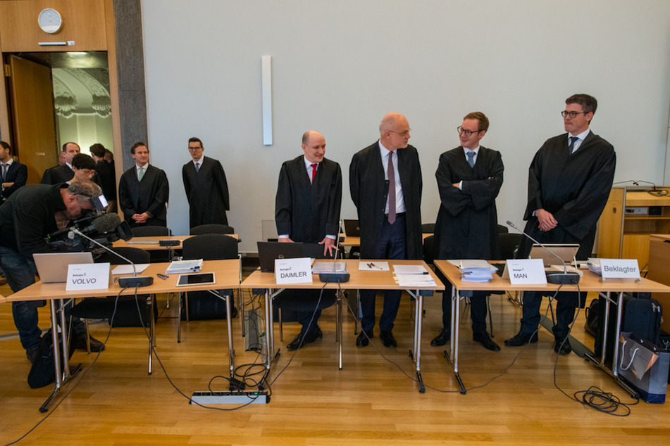 Anwälte der beklagten Firmen stehen vor Beginn des Prozesses 2019 im Münchner Gerichtssaal.