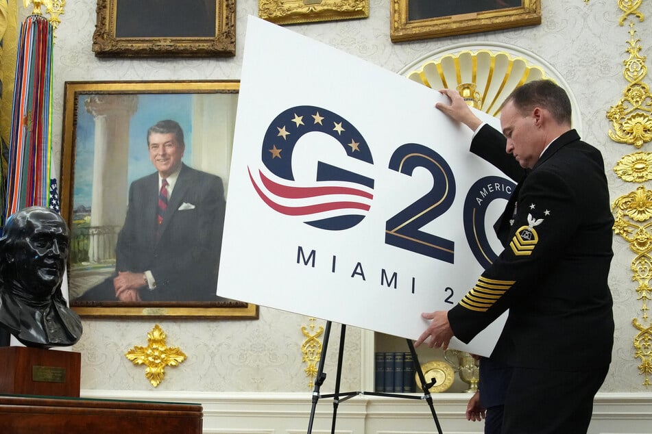 A staff member arranges a display as President Donald Trump announces plans for the 2026 G20 summit during a press availability in the Oval Office of the White House on September 5, 2025.