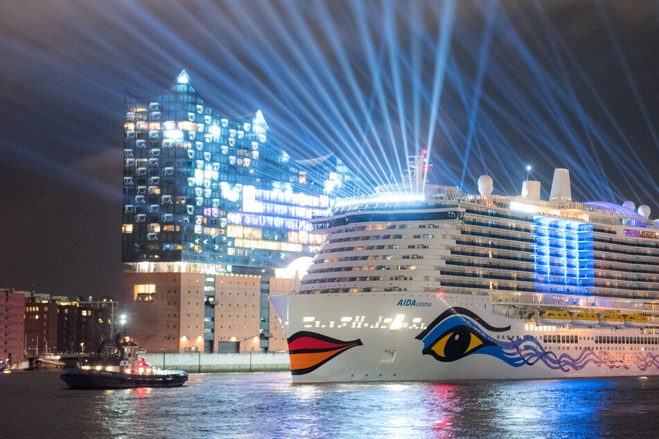 Die "Aidacosma" fährt am Abend nach der Taufzeremonie bunt illuminiert durch den Hamburger Hafen.