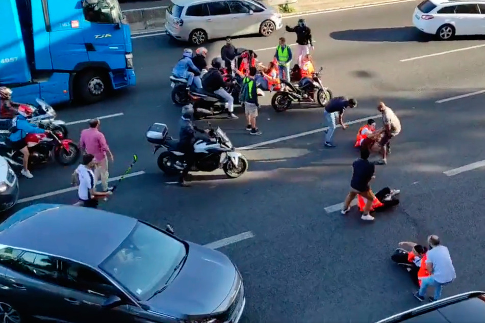 Die Situation eskaliert schnell, als Aktivisten versuchen, die Straße zu blockieren. Ein Autofahrer packt gar einen Hockeyschläger aus.