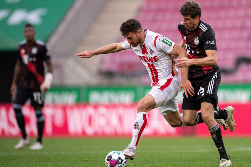 Kölns Salih Özcan (l.) und Bayerns Thomas Müller kämpfen um den Ball.