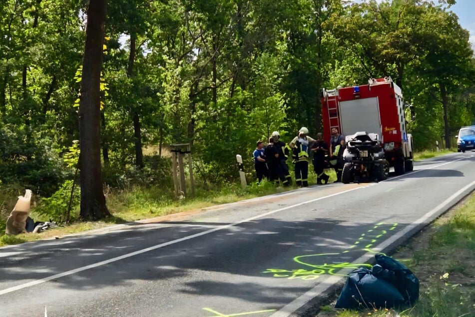 Das verunfallte Quad steht hinter dem Feuerwehrauto. Der Fahrer kam von der Straße ab und krachte gegen einen Baum.