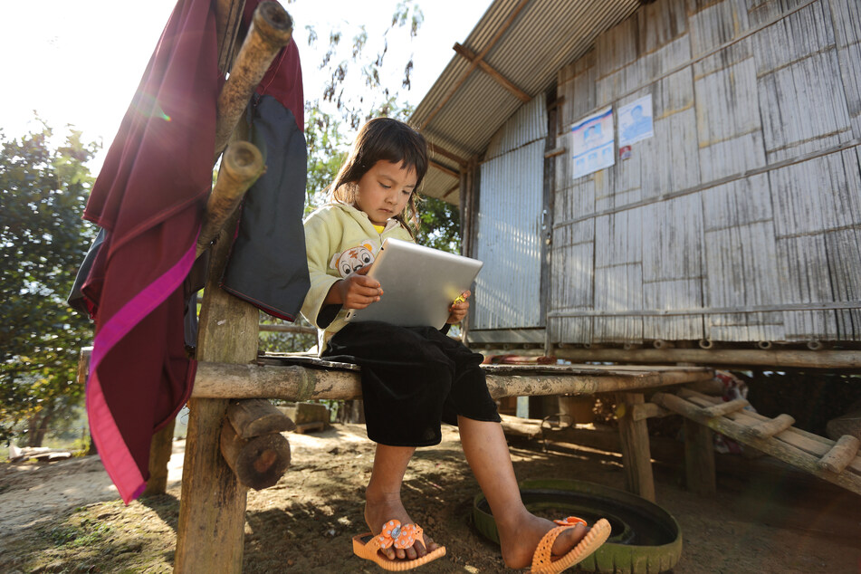A child on a tablet in a rural village in Thailand (stock image).