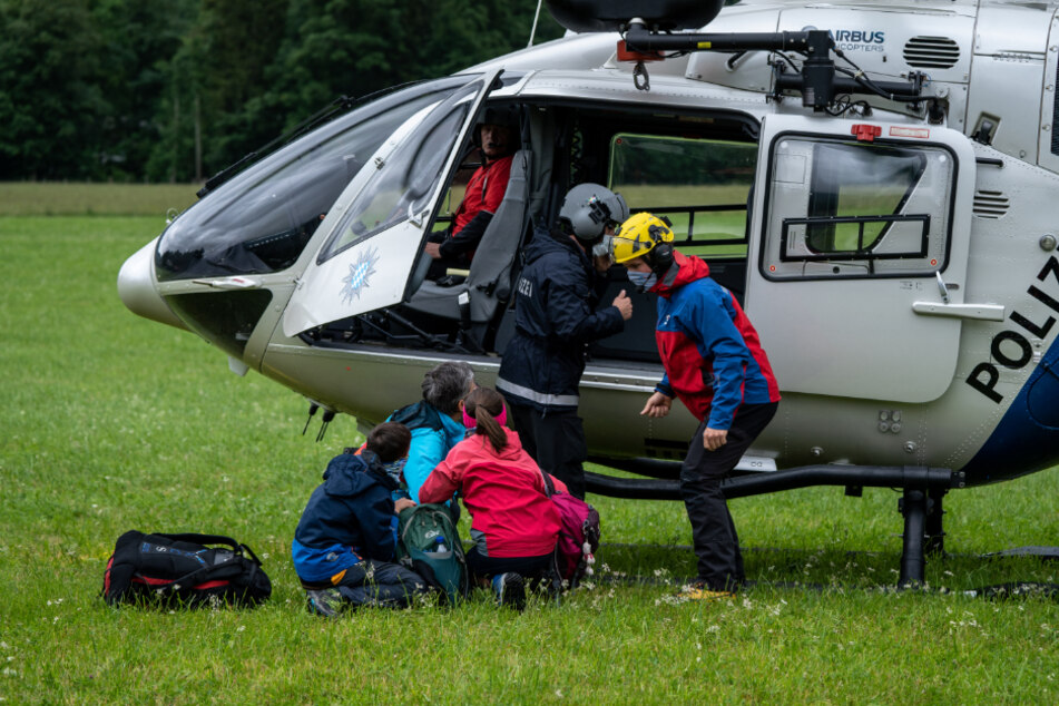Einsatzkräfte der Polizei und der Bergwacht lassen die erste Familie, die sie von der Höllentalangerhütte gerettet haben, im Tal aus dem Hubschrauber.