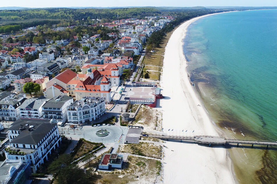 Einzelne Spaziergänger gehen am Strand im Ostseebad Binz auf der Insel Rügen.