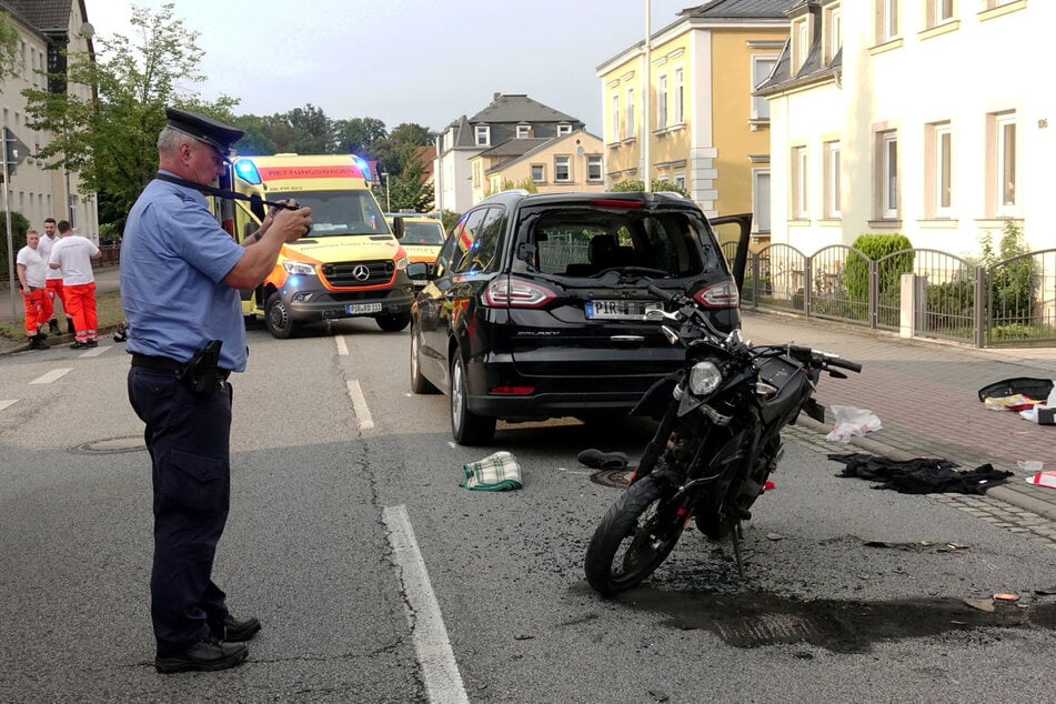 Ein Beamter der Polizei Dresden fotografiert das Motorrad am Unfallort in Dohna.