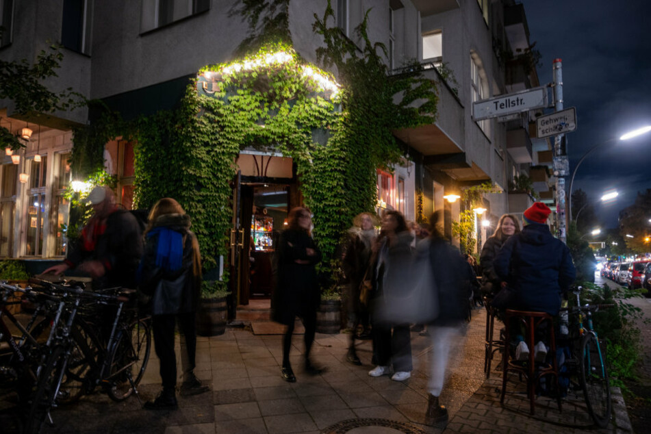 Menschen kommen aus einer Bar im Stadtteil Neukölln, die zur Sperrstunde schließt.