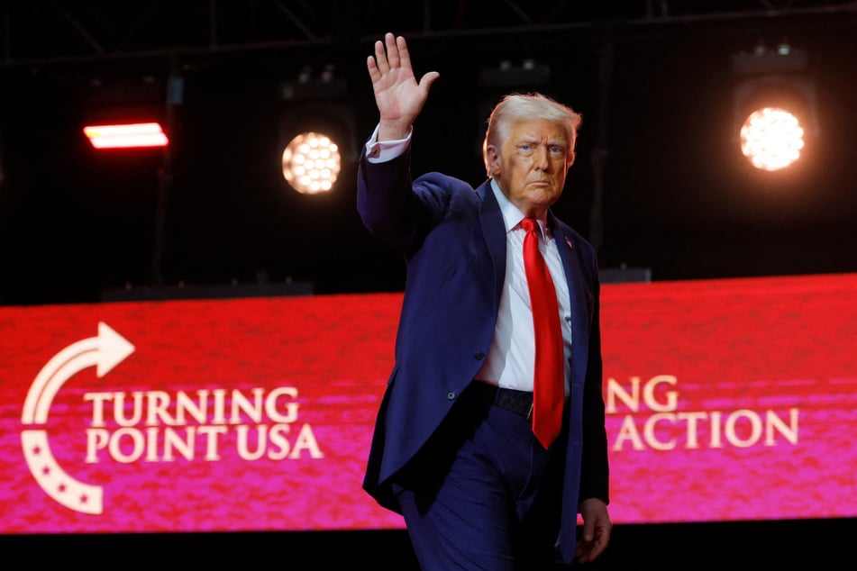 President Donald Trump waves after delivering remarks during a memorial service for Charlie Kirk at State Farm Stadium on September 21, 2025.