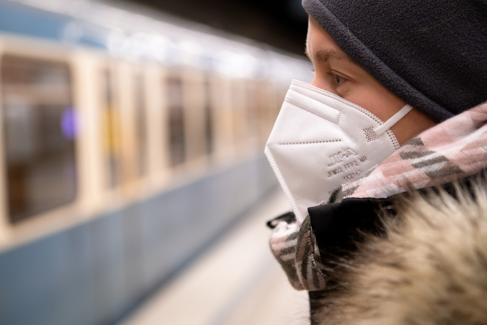 Eine Frau mit FFP2-Maske wartet in einer U-Bahnstation auf die Bahn. In Bayern gilt vom kommenden Montag an eine Pflicht zum Tragen von FFP2-Masken im öffentlichen Nahverkehr und im Einzelhandel.
