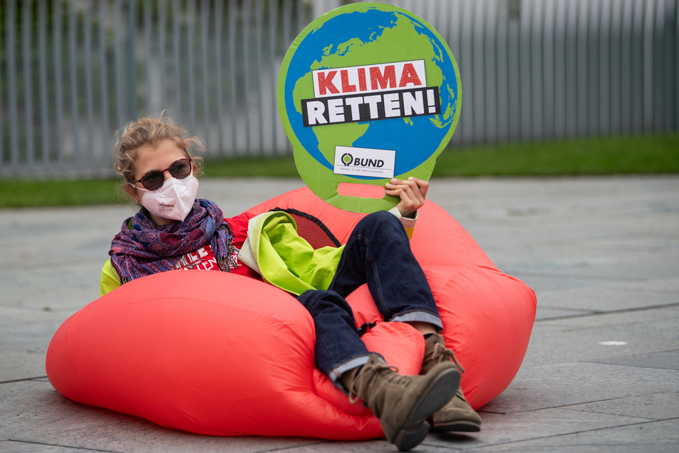 Eine Umweltaktivistin hält bei einer Demonstration für mehr Klimaschutz vor dem Bundeskanzleramt ein Plakat mit der Aufschrift "Klima retten!".