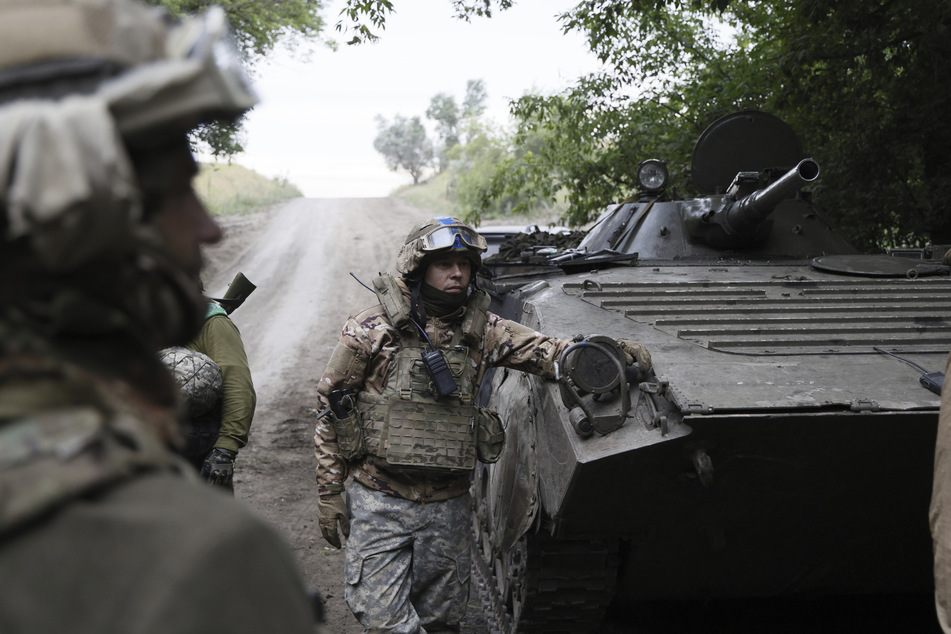 Ukrainische Soldaten stehen in der Nähe ihres Schützenpanzers in der Nähe von Bachmut.