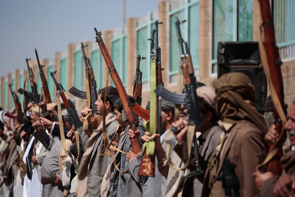nhänger der Houthis tragen ihre Gewehre bei einer Kundgebung.