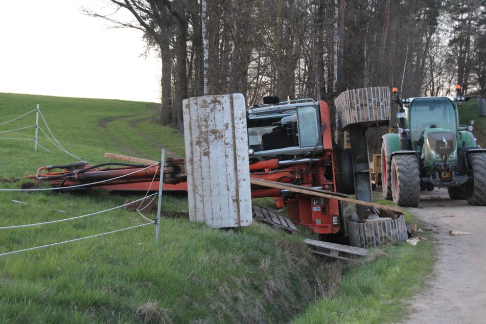 Der Bagger kippte in ein angrenzendes Feld und der Fahrer wurde eingeklemmt.
