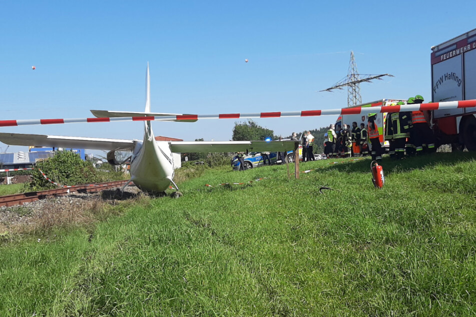 Retter stehen an der Unfallstelle neben dem Ultraleichtflugzeug.