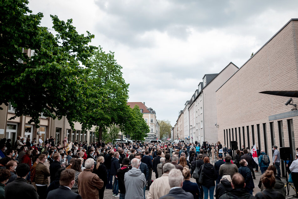Hunderte stehen auf dem Platz vor der Synagoge.