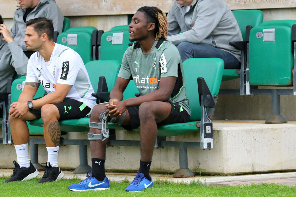 Der verletzte Kouadio Manu Koné (20) darf beim Training nur zuschauen. Hier sitzt er neben Athletiktrainer Jonas Rath (41, l.).