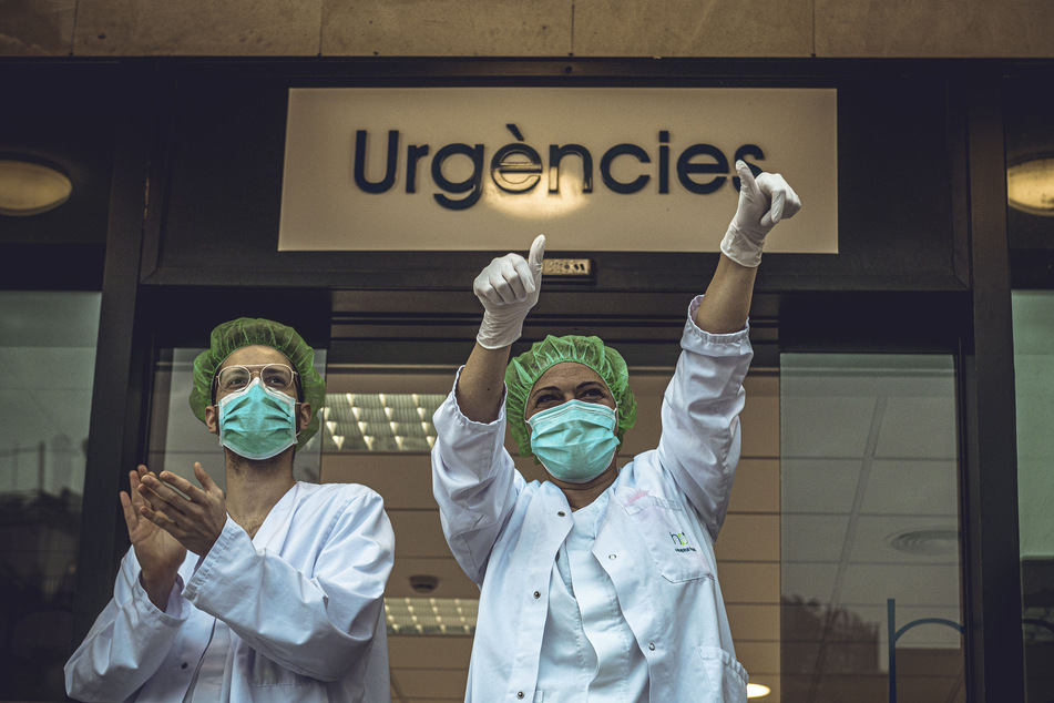 Mitglieder des Gesundheitspersonals der Klinik Plato klatschen und freuen sich über den Applaus, den Anwohner ihnen zur Unterstützung ihrer Arbeit im Kampf gegen das Coronavirus widmen.