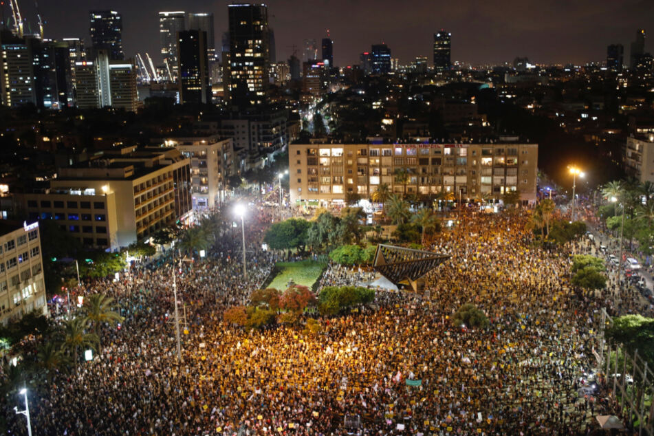Israel, Tel Aviv: Teilnehmer einer regierungskritischen Demonstration stehen auf dem Rabin-Platz.