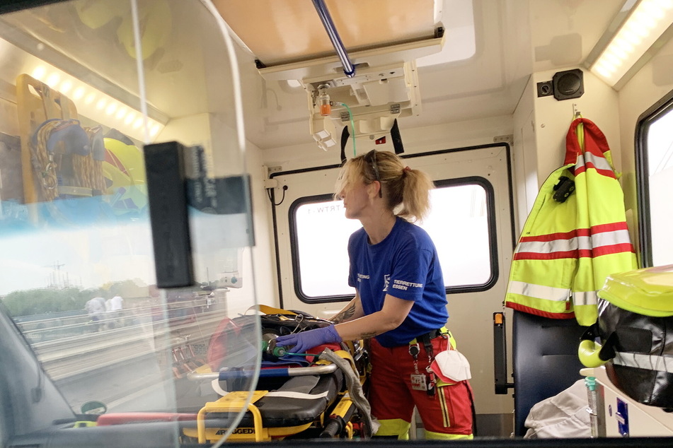 Eine Mitarbeiterin der Tierrettung Essen e. V. versorgt den überhitzten Rüden in einem Rettungswagen.