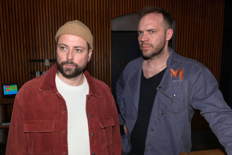 John (l.) ist einer der wenigen Freunde, der noch zu Erik hält und lässt ihn im Mauerwerk nächtigen.