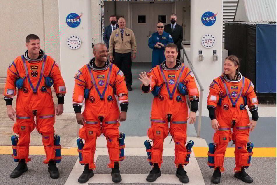 (From l. to r.) Astronauts Jeremy Hansen, Victor Glover, Reid Wiseman, and Christina Koch walk out before traveling to the launch pad for the Artemis II crewed lunar mission on Wednesday.