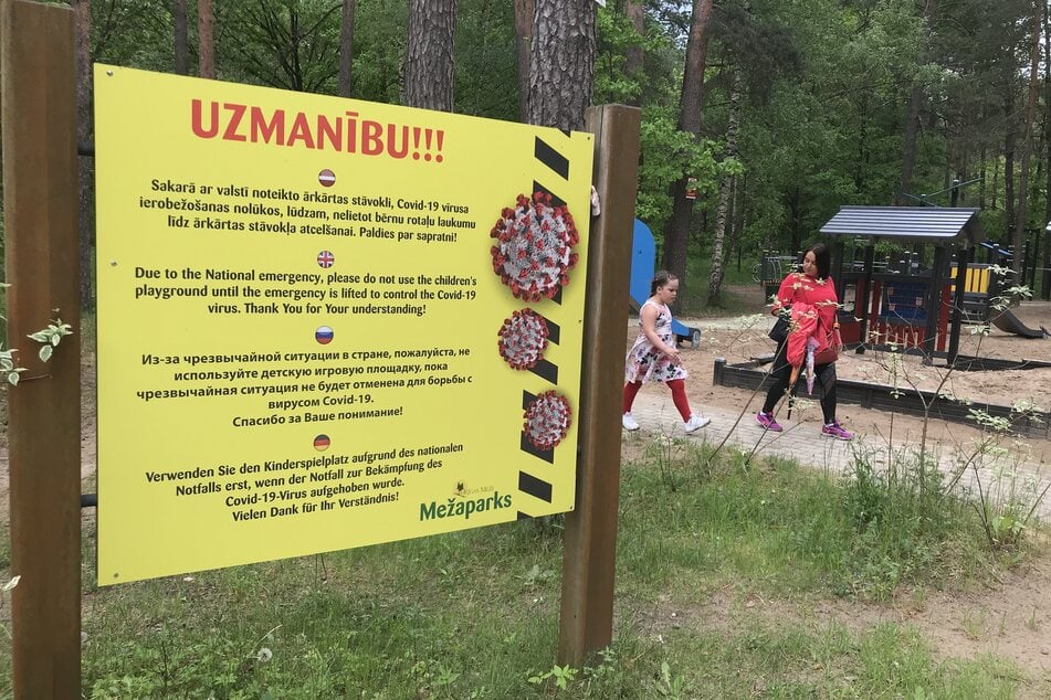 Ein Hinweisschild steht neben einem Spielplatz im beliebten Naherholungsgebiets Mezaparks in der lettischen Hauptstadt Riga.