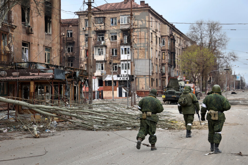 Soldaten der Miliz der Volksrepublik Donezk gehen durch die zerstörte Hafenstadt Mariupol. Ukrainische Truppen haben um Evakuierung gebeten.