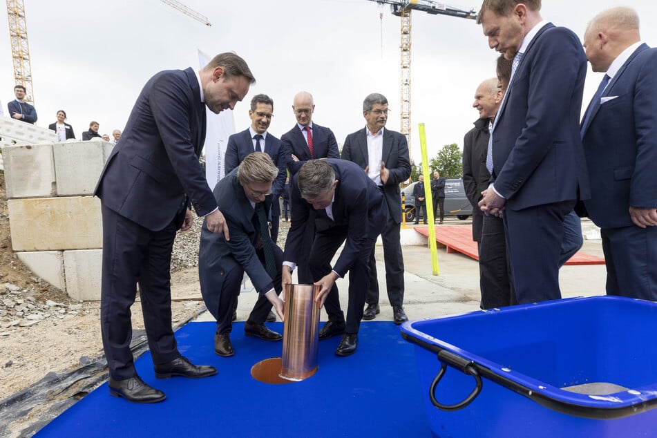 Landtagspräsident Alexander Dierks, Geschäftsführer Oliver Wehner und Sana-Vorstandsvorsitzender Thomas Lemke (v.l.) versenken die Zeitkapsel, rechts MP Michael Kretschmer.