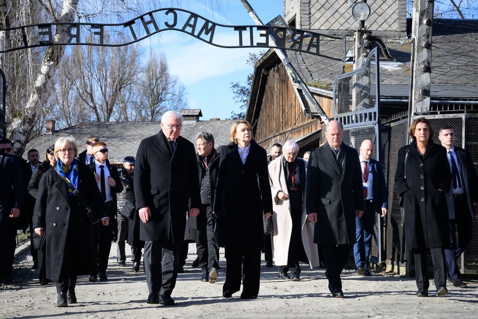 Bundespräsident Frank-Walter Steinmeier (69, 4.v.r.) und seine Frau Elke Büdenbender (63, 3.v.r.) gehen zusammen mit Bundeskanzler Olaf Scholz (66, 2.v.r., SPD) und seiner Frau Britta Ernst (63, r.) durch das Tor des ehemaligen deutschen Konzentrations- und Vernichtungslagers Auschwitz-Birkenau.