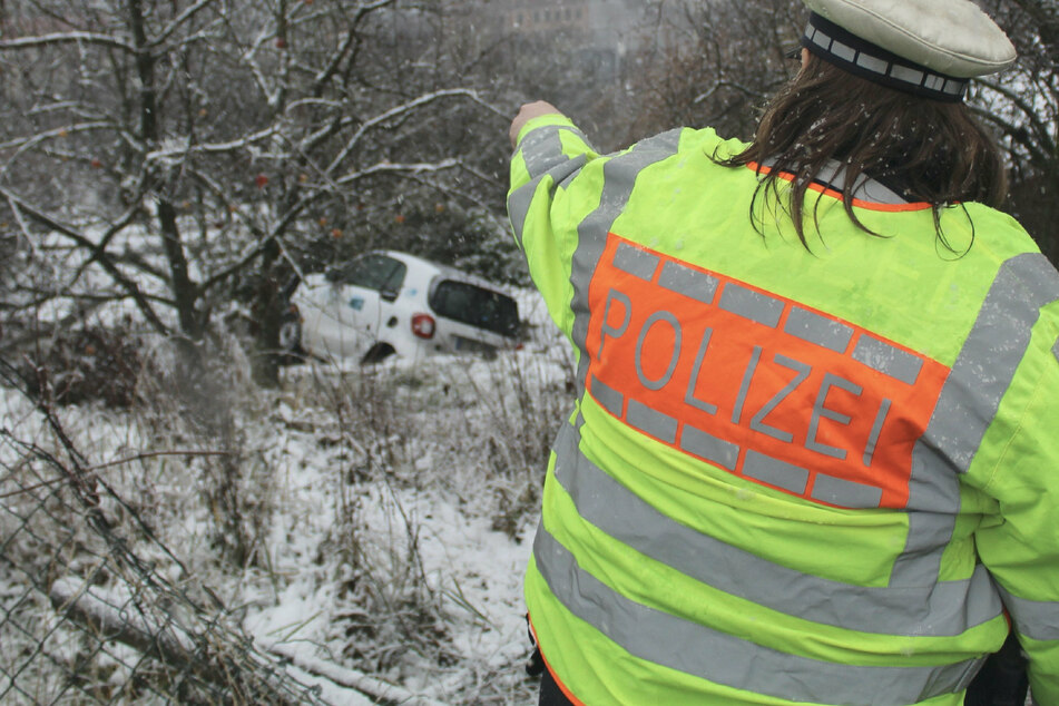 Eine Polizistin zeigt auf den Unfallwagen.