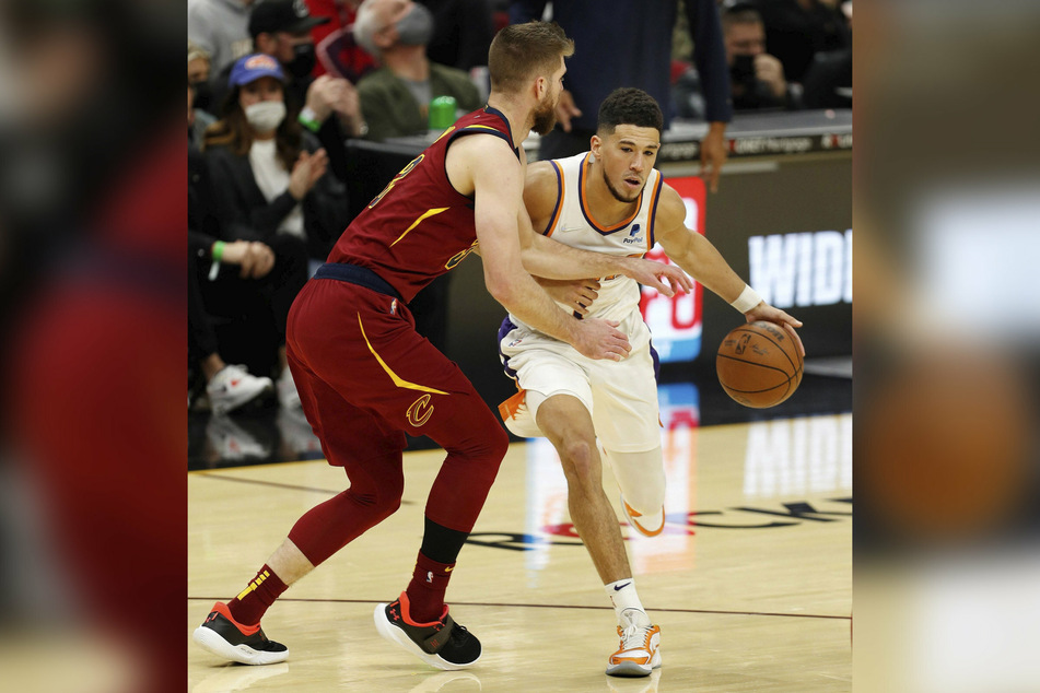 Devin Booker (r.) scored 24 of his game-high 35 points in the first half as the Phoenix Suns held off a late challenge from the Cavaliers.