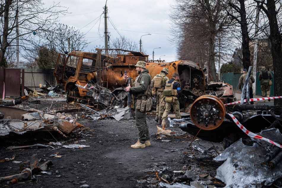 Der Blitzkrieg-Versuch auf Kiew scheiterte nach wenigen Wochen. Als sich der Nebel rings um die Hauptstadt lichtete, deckten sich erste Kriegsverbrechen auf. Soldaten dokumentieren hier auf den Straßen des Kiewer Vororts Irpin das Ausmaß der Zerstörung.
