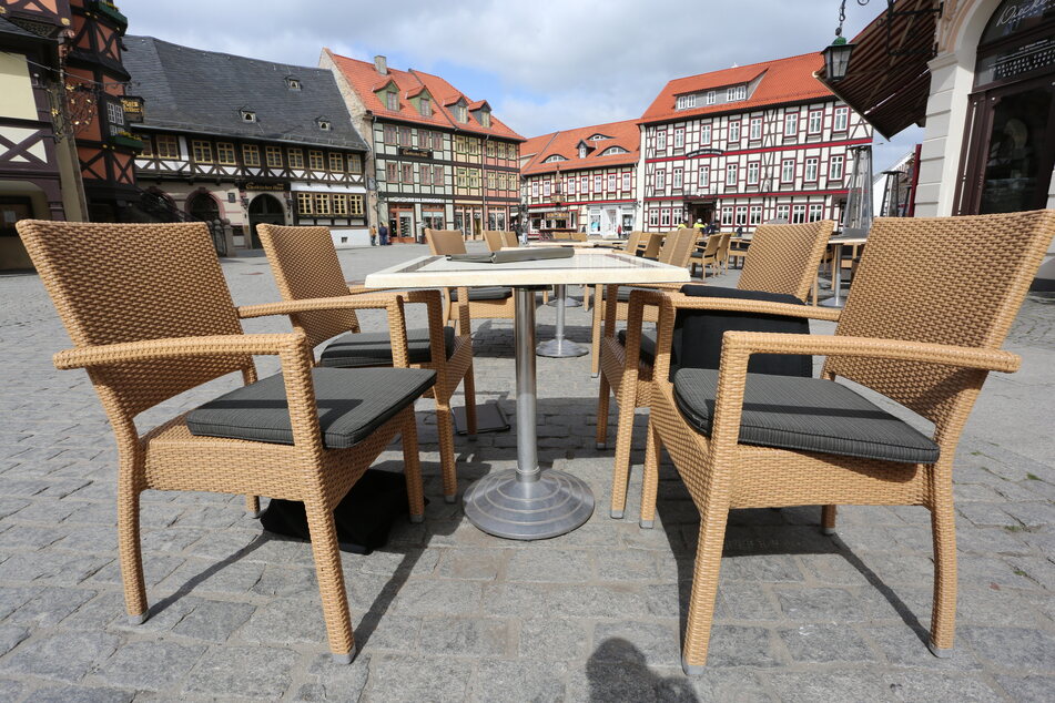 Auf dem Marktplatz stehen leere Tische und Stühle vor einem Café.