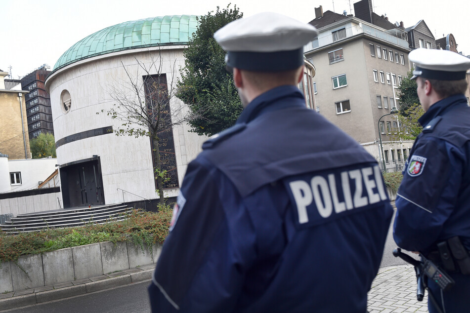 Polizisten stehen vor eine Synagoge in Düsseldorf. Am Montagabend hat ein Unbekannter auf dem Denkmal für die ehemalige große Synagoge in der Stadt ein Feuer gelegt. Nun ermittelt der Staatsschutz. (Archivbild)