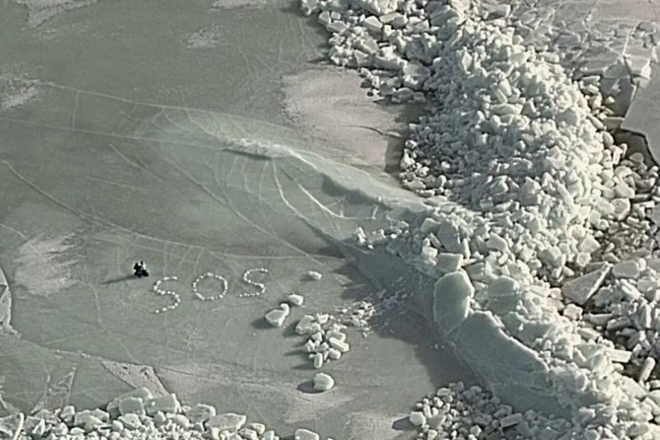Z użyciem śniegu i lodu duet ułożył duży znak SOS, aby został zauważony przez ratownicze zespoły z powietrza.