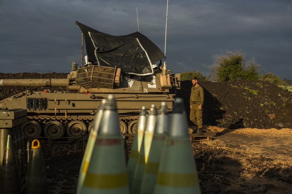 Ein israelischer Artilleriesoldat steht nahe der Grenze zu Libanon neben einem Panzer.