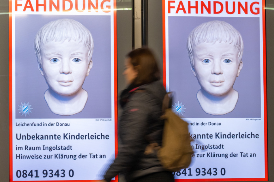 Am Münchner Ostbahnhof wird das Fahndungsplakat angezeigt. Es zeigt das rekonstruierte Bild des toten Jungen.