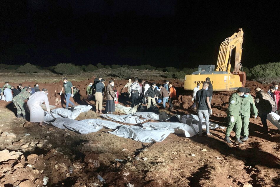 Arbeiter in Darna begraben die Leichen der Opfer die bei dem verheerenden Unwetter ums Leben gekommen sind.