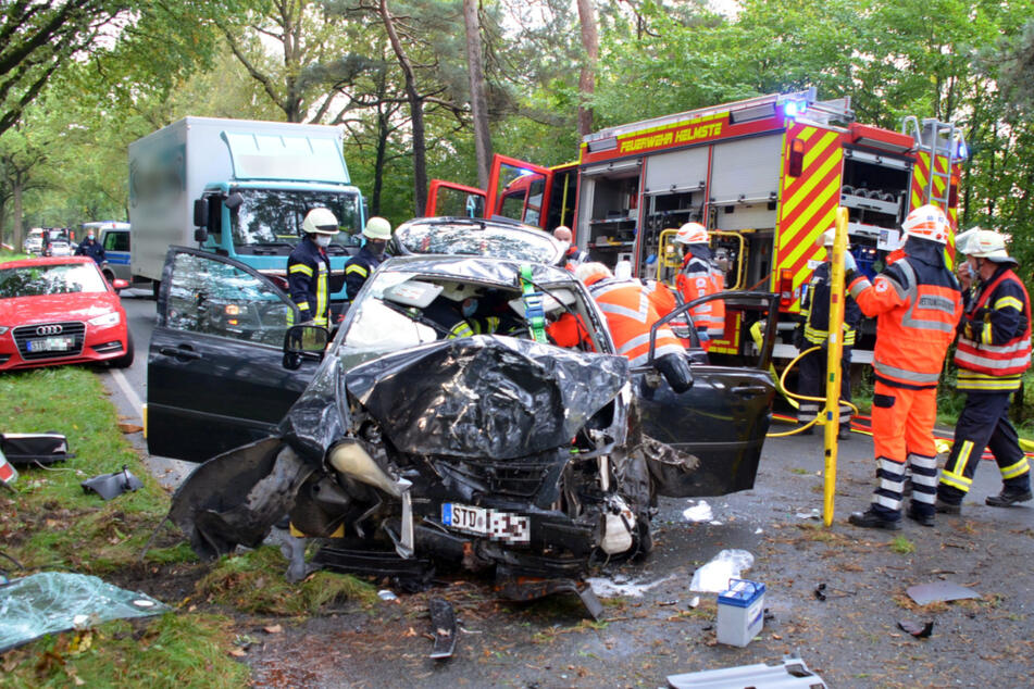 Einsatzkräfte der Feuerwehr befreien das Unfallopfer aus dem Wagen.
