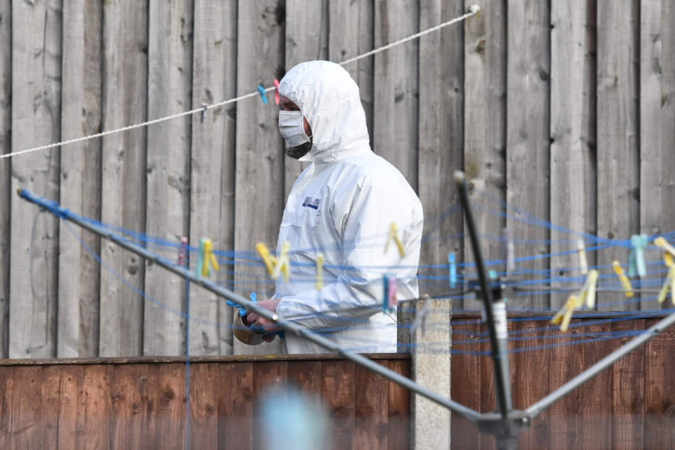 Kriminaltechniker durchsuchen ein Grundstück im Zusammenhang mit dem Attentat.