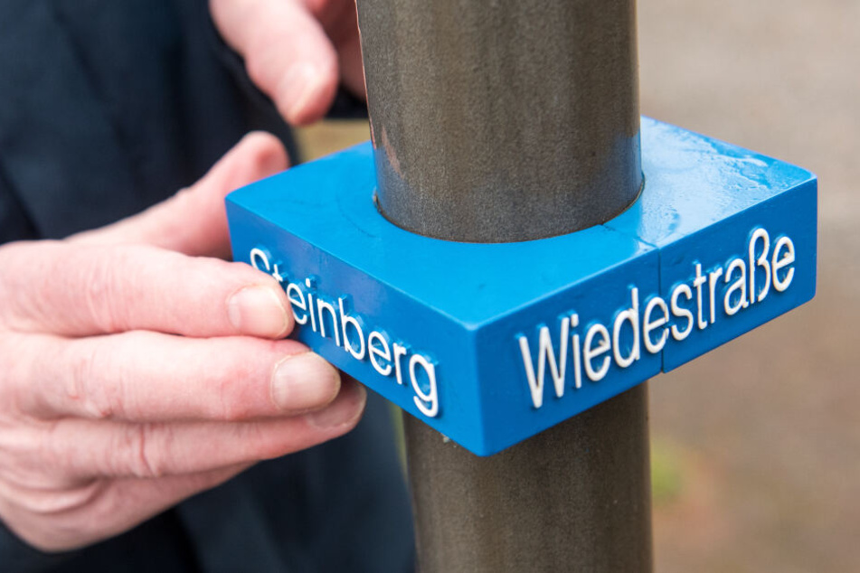 Am Mast des Straßenschilds wurde ein zusätzliches kleines Schild für Sehbehinderte montiert.