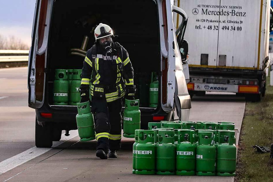 Ein Feuerwehrmann lädt die gefährliche Fracht aus dem verunfallten Kleintransporter.
