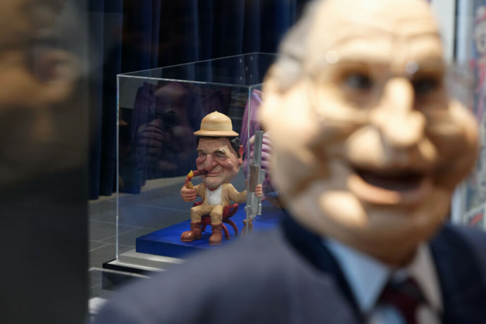Die Karikatur von Gerhard Schröder in einem Glaskasten.