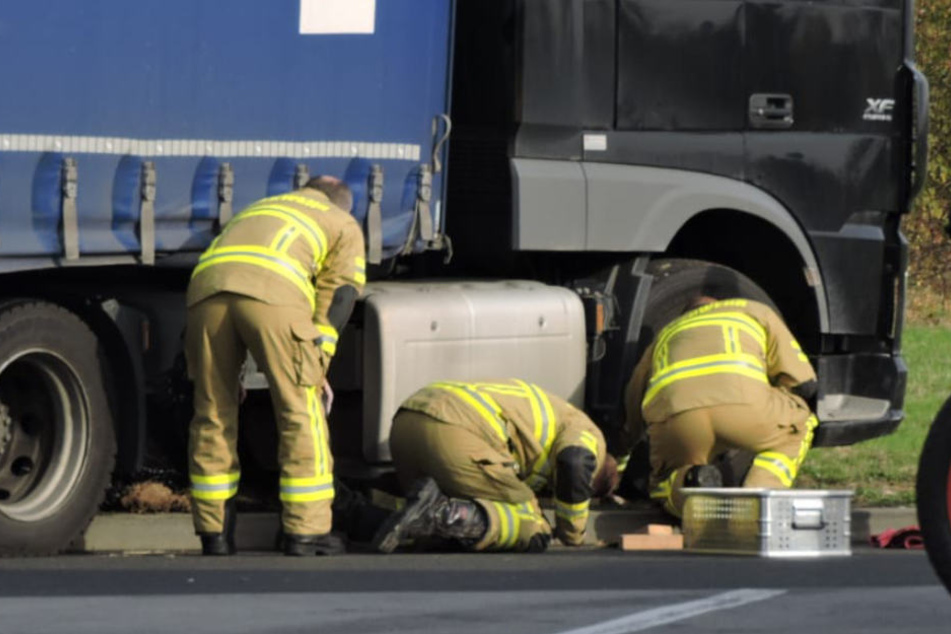 Kameraden der Feuerwehr Grimma begutachten den verunfallten Lastwagen.