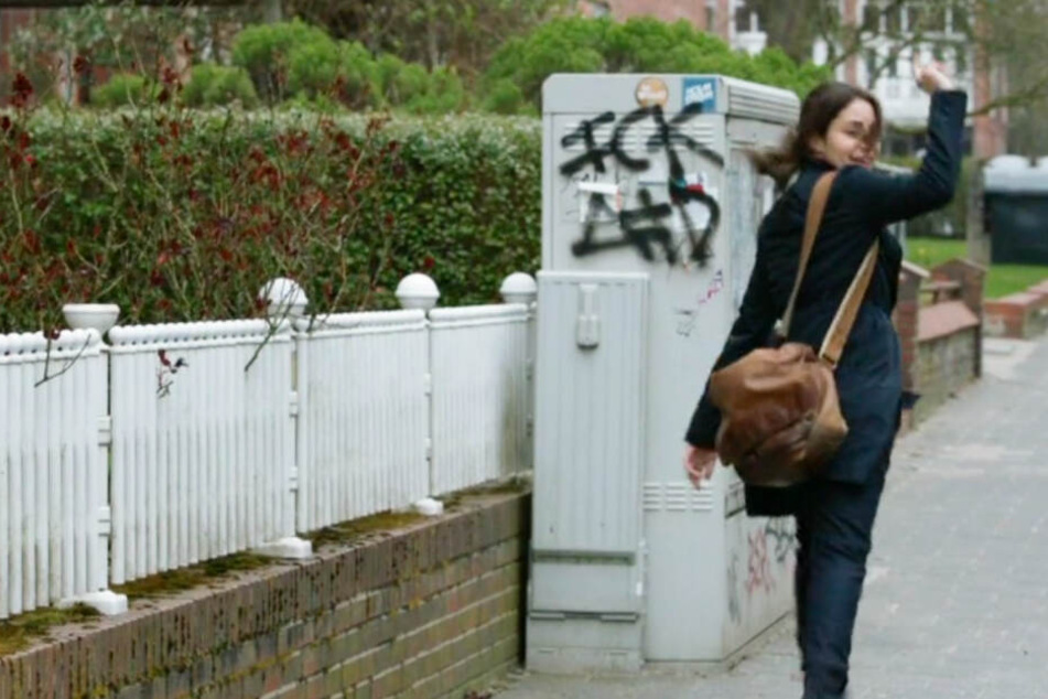 Kommissarin Mila Sahin (Almila Bagriacik) läuft in einer Tatort-Szene an einem Verteilerkasten mit dem Graffito "FCK AFD" vorbei.