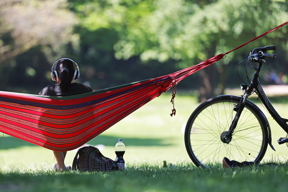 Eine Frau genießt im Kölner Volksgarten die Sonne. Die Temperaturen in NRW erreichen am Dienstag bis zu 19 Grad bei strahlendem Sonnenschein.